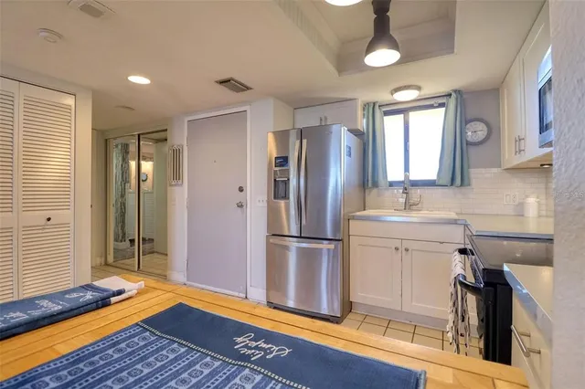 a kitchen with a refrigerator sink and cabinets