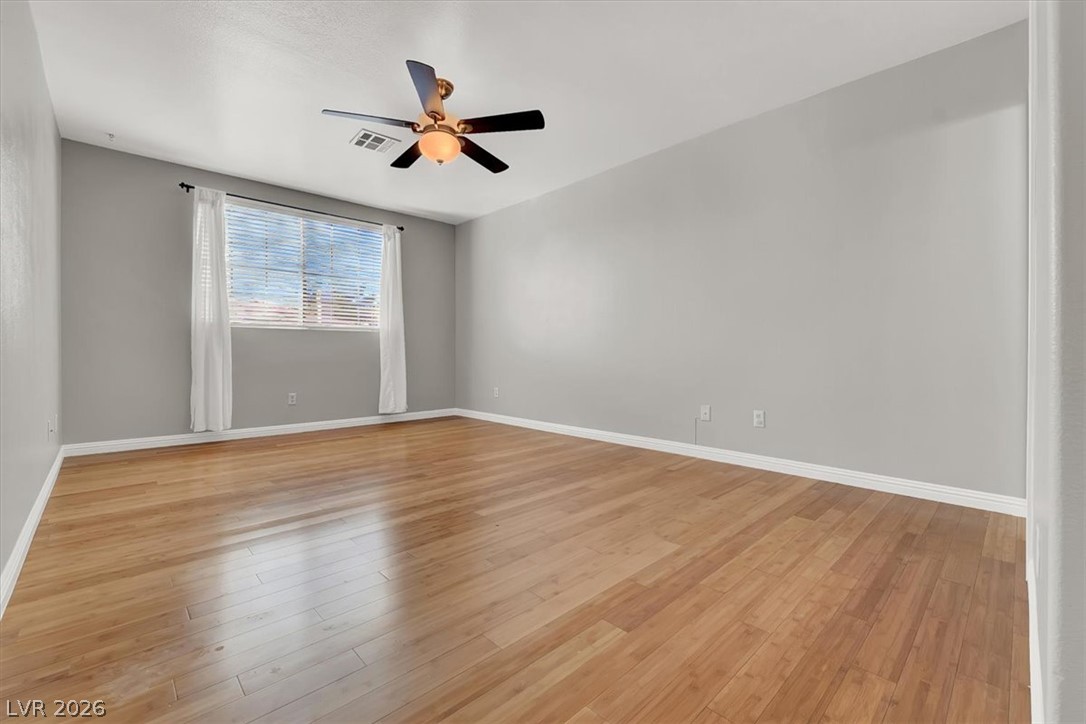 10148 Tree Bark Street Las Vegas, NV 89183 - Photo 26 of 37 Hardwood floors and ample natural light enhance this adaptable bedroom space.