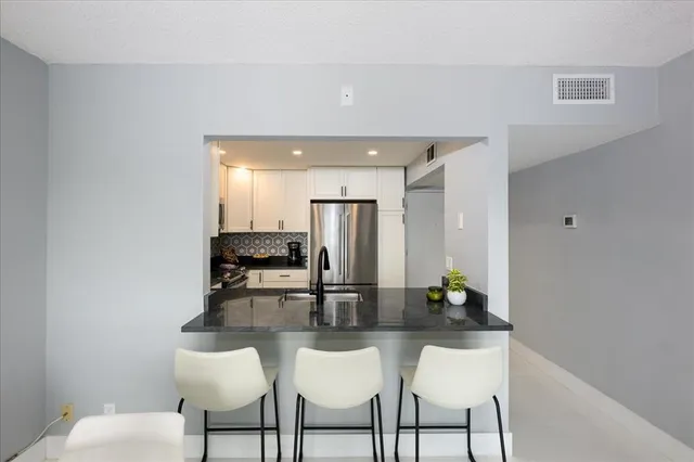 a kitchen with stainless steel appliances kitchen island granite countertop a table and chairs