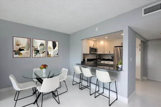 a dining room with furniture and a kitchen area