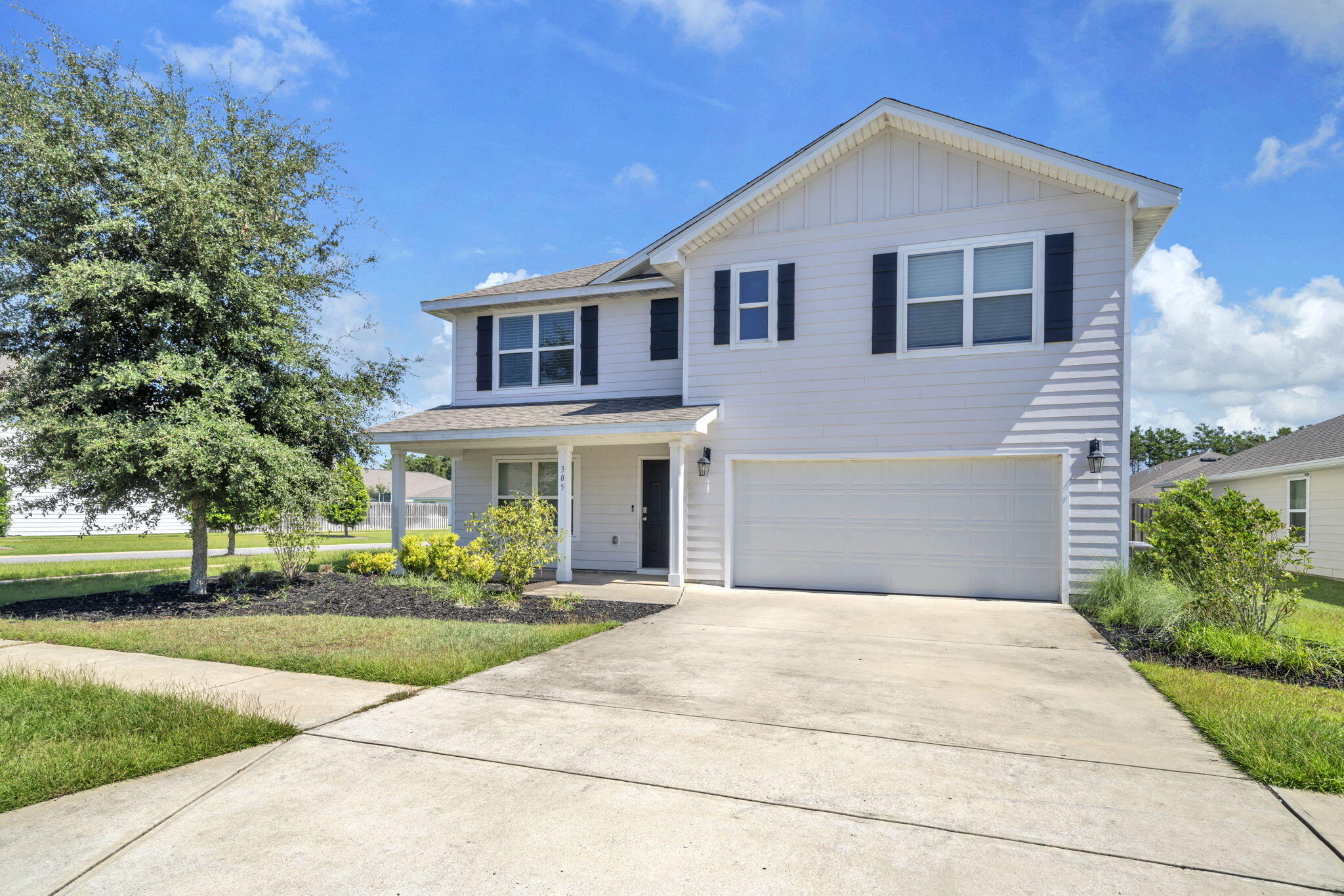 a front view of a house with a yard and potted plants
