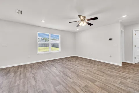 wooden floor in an empty room with a window