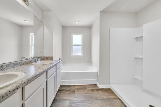 a bathroom with a granite countertop sink mirror bathtub and shower