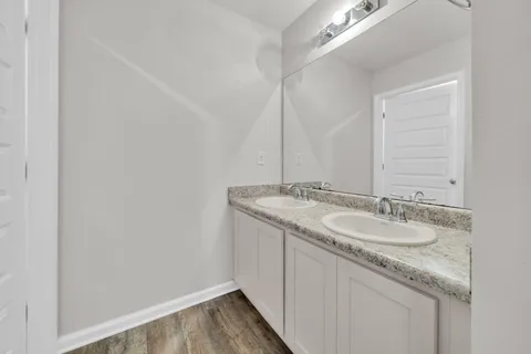 a bathroom with a granite countertop sink and a mirror