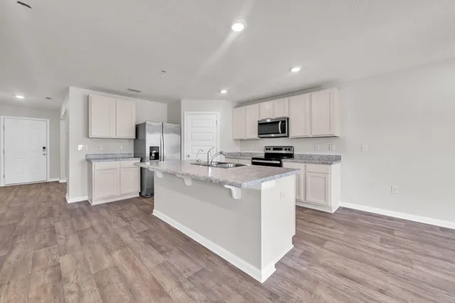 a kitchen with white cabinets and stainless steel appliances