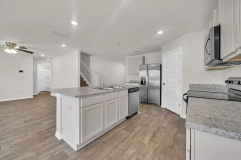 a kitchen with stainless steel appliances granite countertop a sink stove and refrigerator