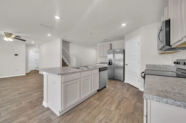a kitchen with stainless steel appliances granite countertop a sink stove and refrigerator