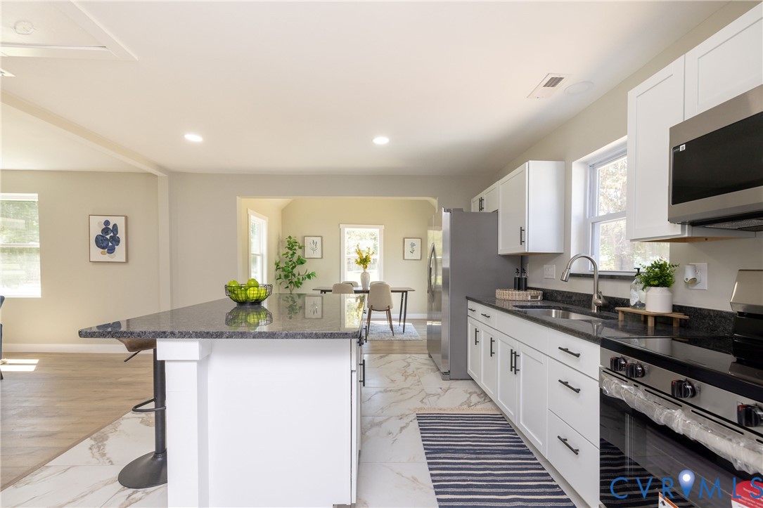 7272 Willson Road Henrico, VA 23231 - Photo 15 of 47 a kitchen with stainless steel appliances kitchen island granite countertop a stove and a sink