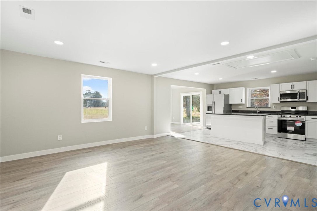 7272 Willson Road Henrico, VA 23231 - Photo 47 of 47 an empty room with wooden floor and kitchen view