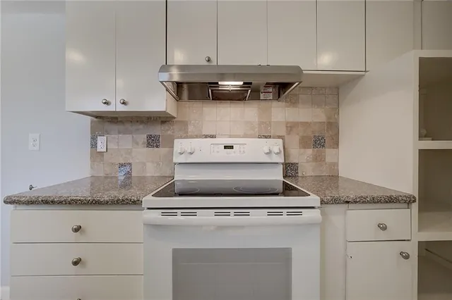 a stove top oven sitting inside of a kitchen