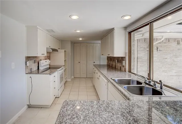 a kitchen with stainless steel appliances granite countertop a sink a stove and a refrigerator