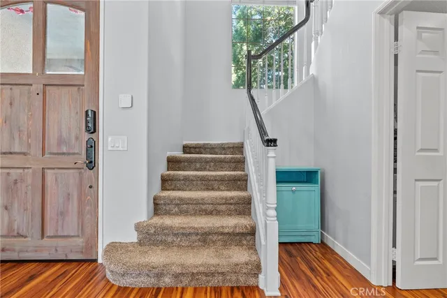 a view of entryway and hall with wooden floor