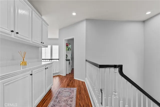 a view of hallway with window and wooden floor
