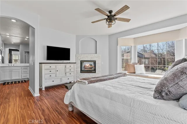 a bedroom with furniture a flat screen tv and a fireplace