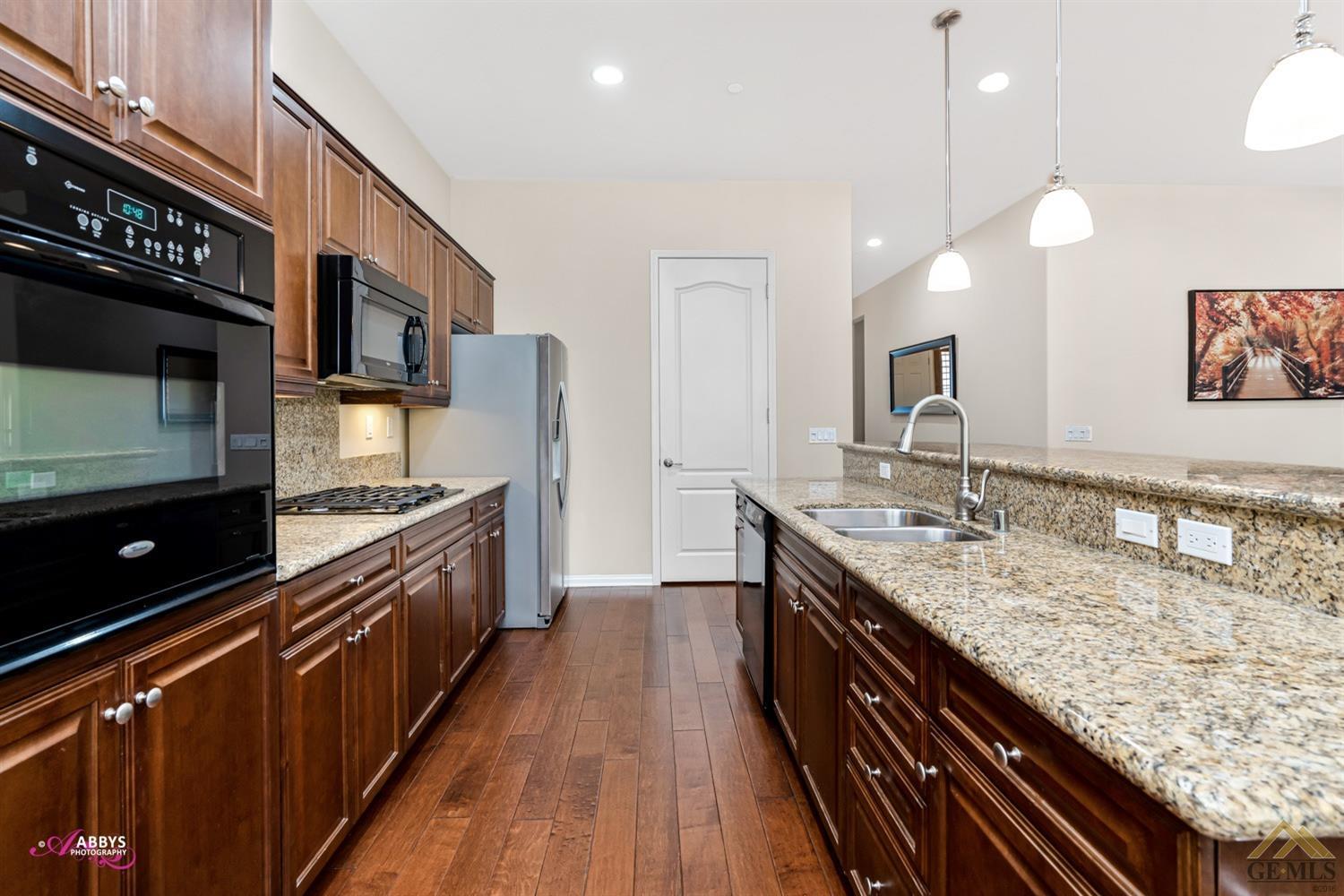 Undisclosed Address Bakersfield, CA 93306 - Photo 11 of 48 a kitchen with granite countertop stainless steel appliances and wooden cabinets