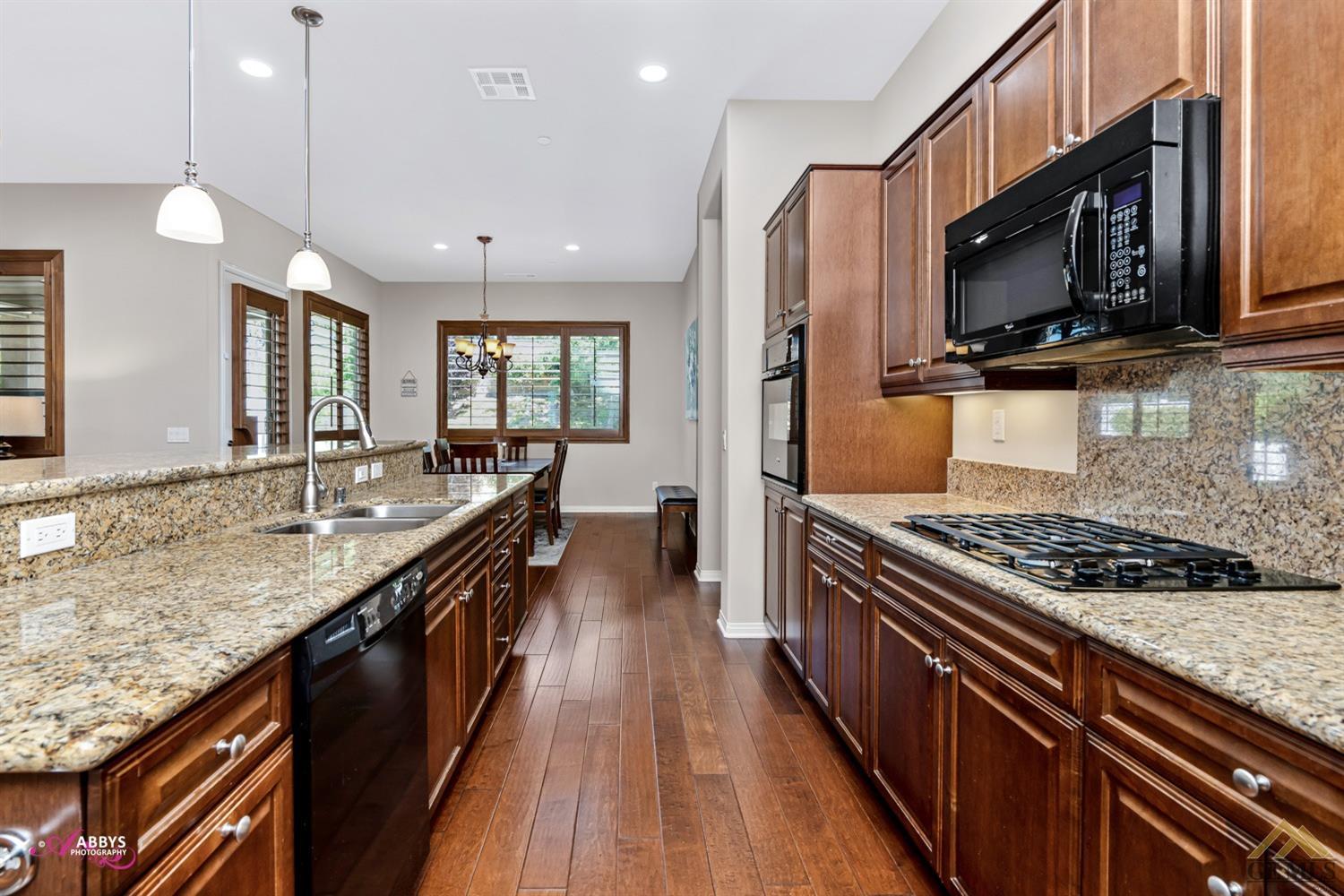 Undisclosed Address Bakersfield, CA 93306 - Photo 12 of 48 a kitchen with stainless steel appliances granite countertop a stove a sink and a microwave