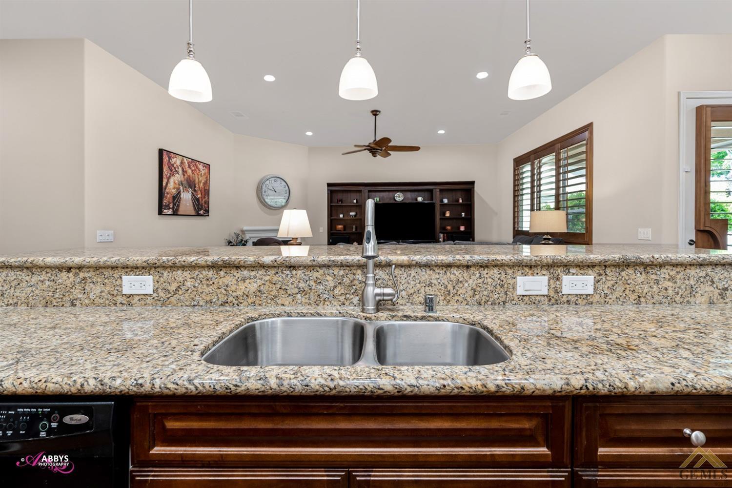 Undisclosed Address Bakersfield, CA 93306 - Photo 14 of 48 a kitchen with kitchen island granite countertop a sink a counter space and cabinets