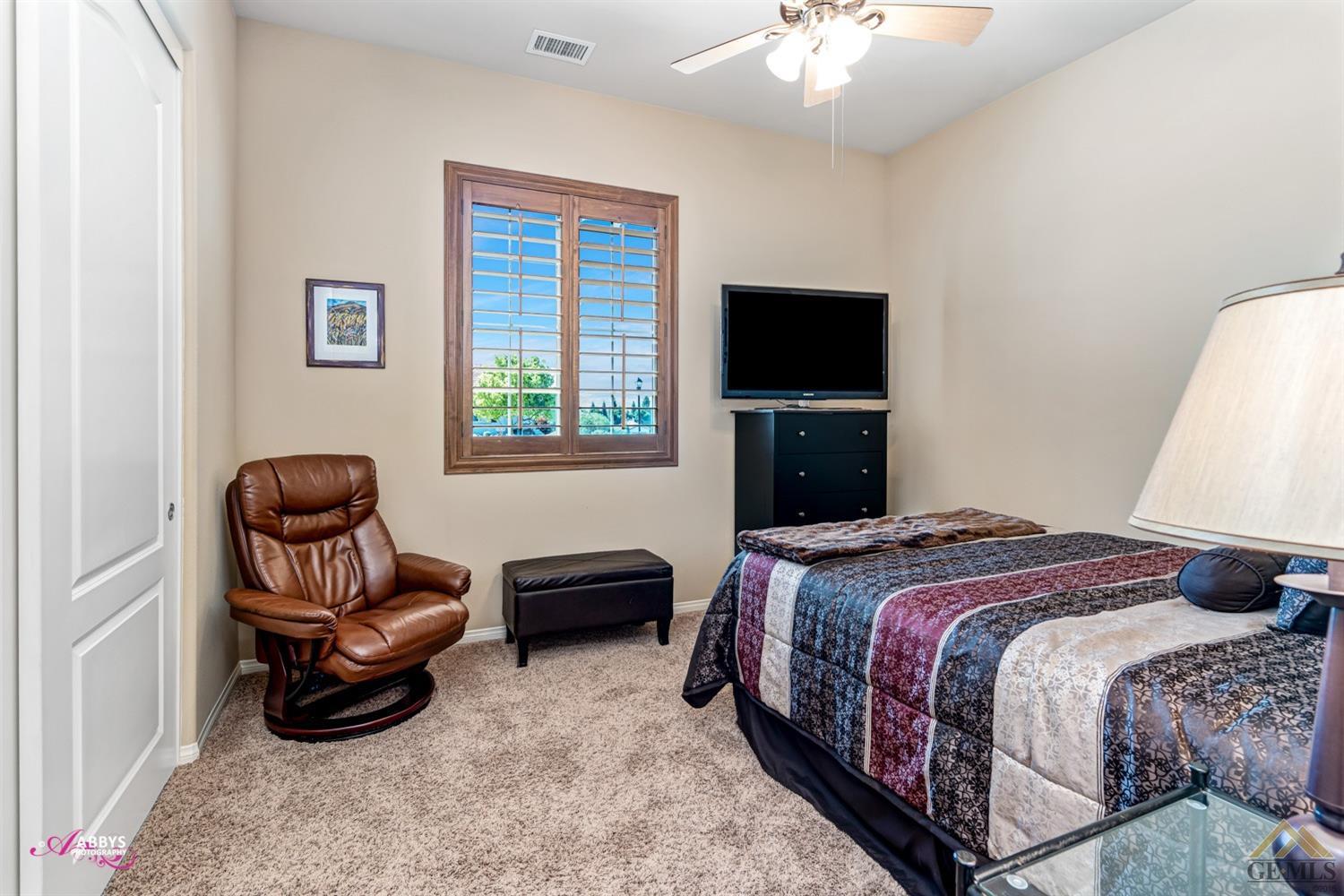 Undisclosed Address Bakersfield, CA 93306 - Photo 18 of 48 a bedroom with a bed and a chair