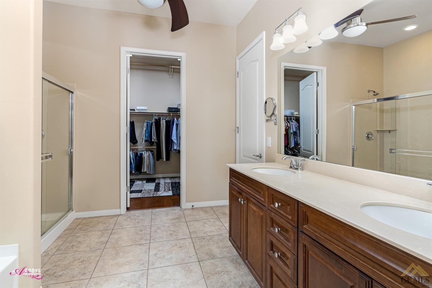 Undisclosed Address Bakersfield, CA 93306 - Photo 22 of 48 a spacious bathroom with a double vanity sink and a mirror