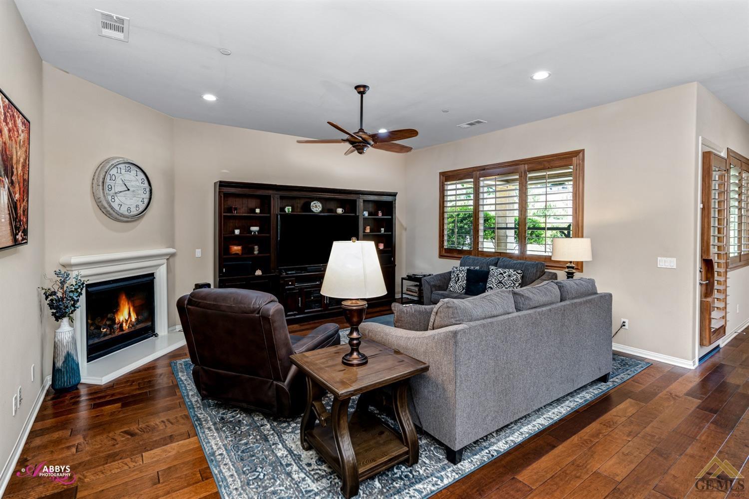 Undisclosed Address Bakersfield, CA 93306 - Photo 7 of 48 a living room with furniture a clock and a fireplace