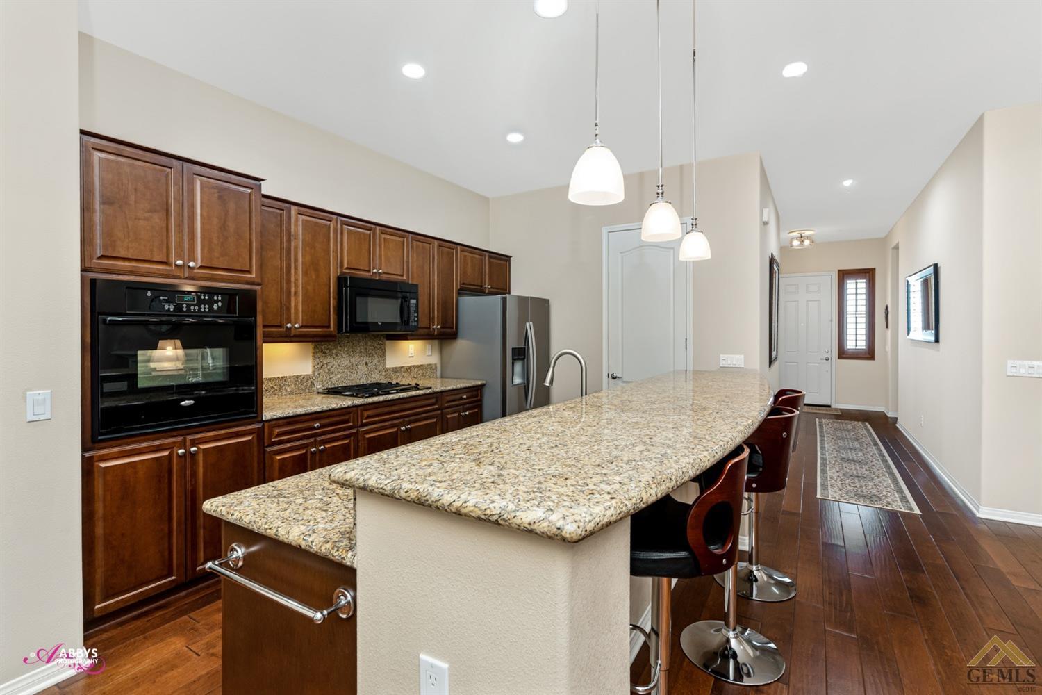 Undisclosed Address Bakersfield, CA 93306 - Photo 10 of 48 a kitchen with stainless steel appliances granite countertop a kitchen island a stove and a wooden floors