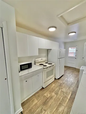 a view of a room with wooden floor and white walls