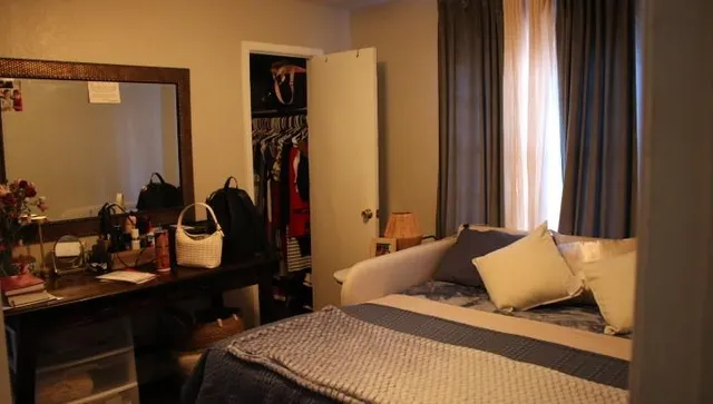 a bedroom with a bed and dresser with mirror