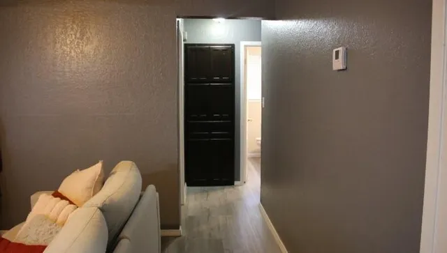 a view of a hallway with wooden floor and glass door