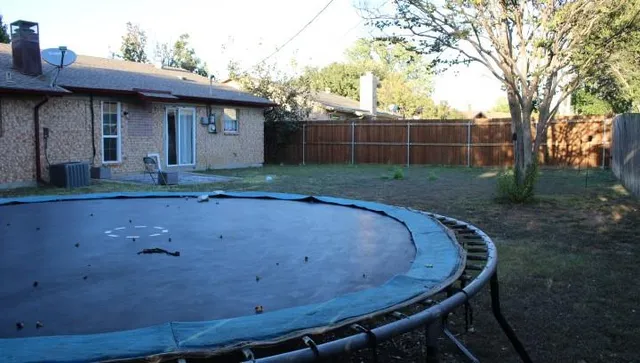 a view of a backyard with wooden fence