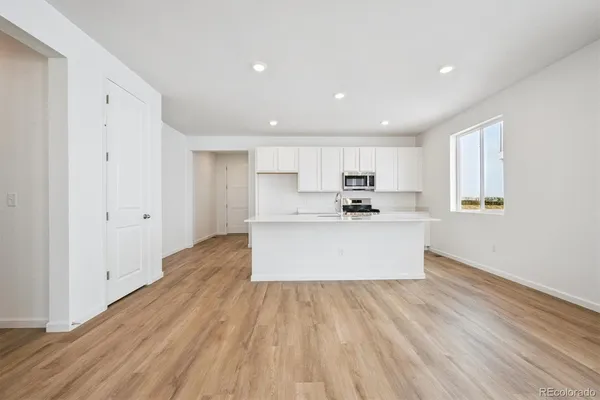 a view of kitchen with wooden floor and electronic appliances