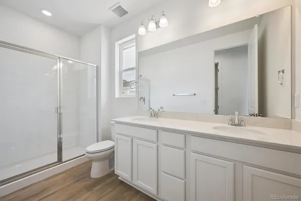 a bathroom with a double vanity sink toilet and a mirror