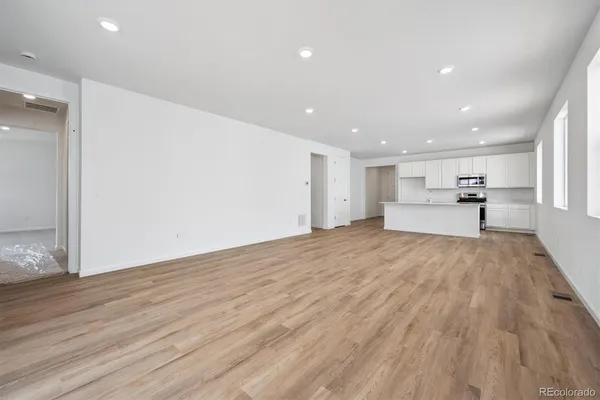 a view of empty room with wooden floor