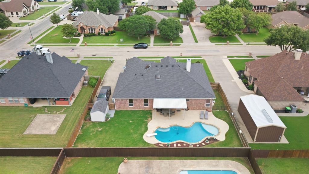 603 Cedar Drive Pilot Point, TX 76258 - Photo 34 of 39 Rear exterior with a free-form swimming pool, covered patio, and extensive lawn space
