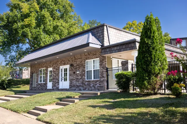 a front view of a house with a garden and swimming pool