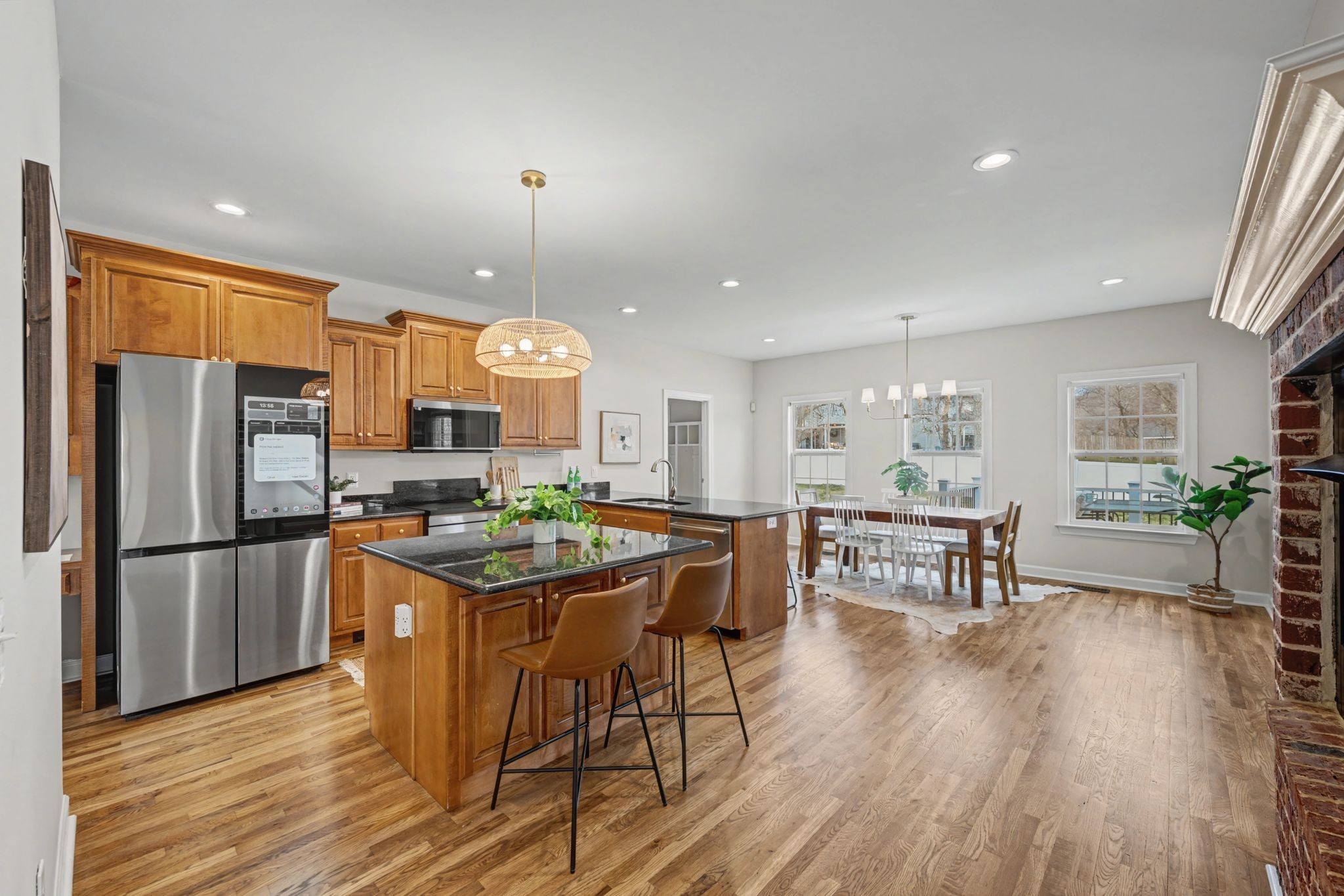 1060 Auldridge Drive Spring Hill, TN 37174 - Photo 6 of 49 a kitchen with stainless steel appliances granite countertop a stove top oven a refrigerator a dining table and chairs with wooden floor