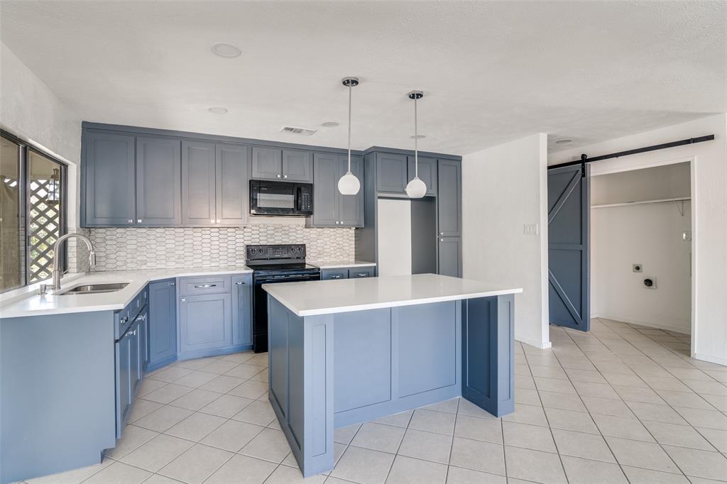 3630 Dumas Trail Garland, TX 75043 - Photo 3 of 12 a kitchen with stainless steel appliances a stove sink and cabinets
