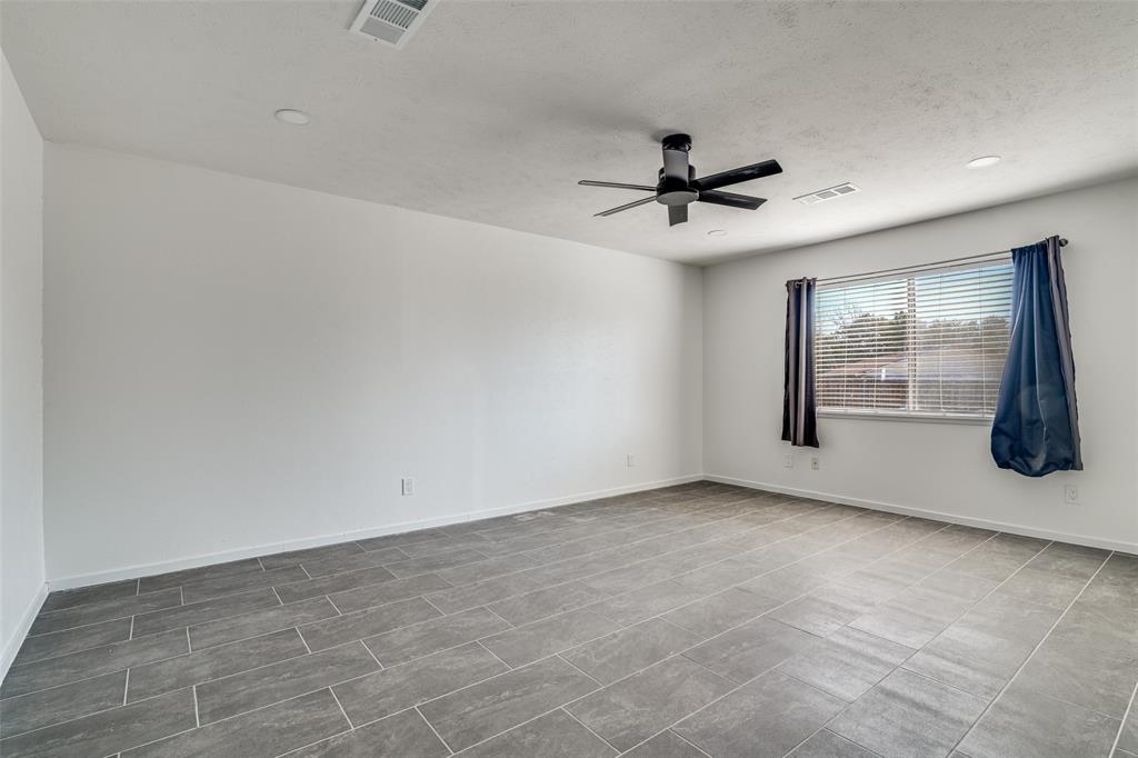 3630 Dumas Trail Garland, TX 75043 - Photo 7 of 12 an empty room with chandelier fan and windows