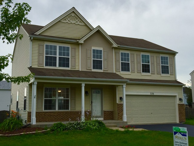 326 Prairie Ridge Drive Minooka, IL 60447 - Photo 2 of 16 a front view of a house with a yard and garage
