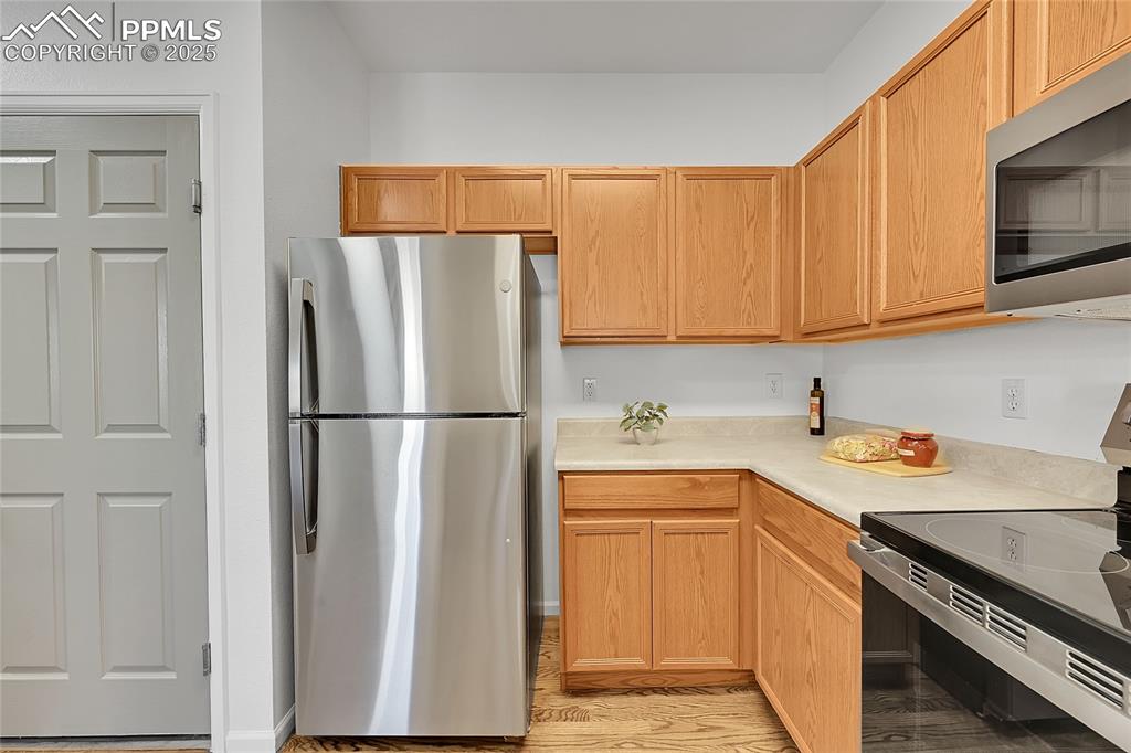 6232 Sierra Grande Point Colorado Springs, CO 80923 - Photo 12 of 31 a kitchen with a sink a refrigerator and cabinets
