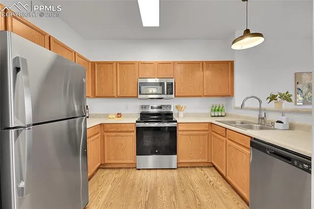 a kitchen with stainless steel appliances a refrigerator sink and microwave