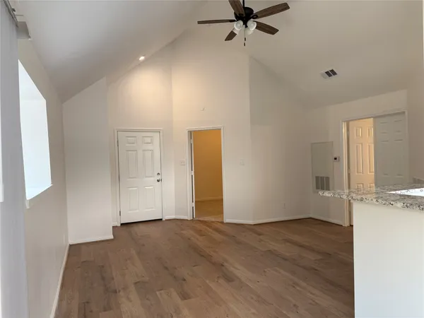 a view of a livingroom with a hall and wooden floor
