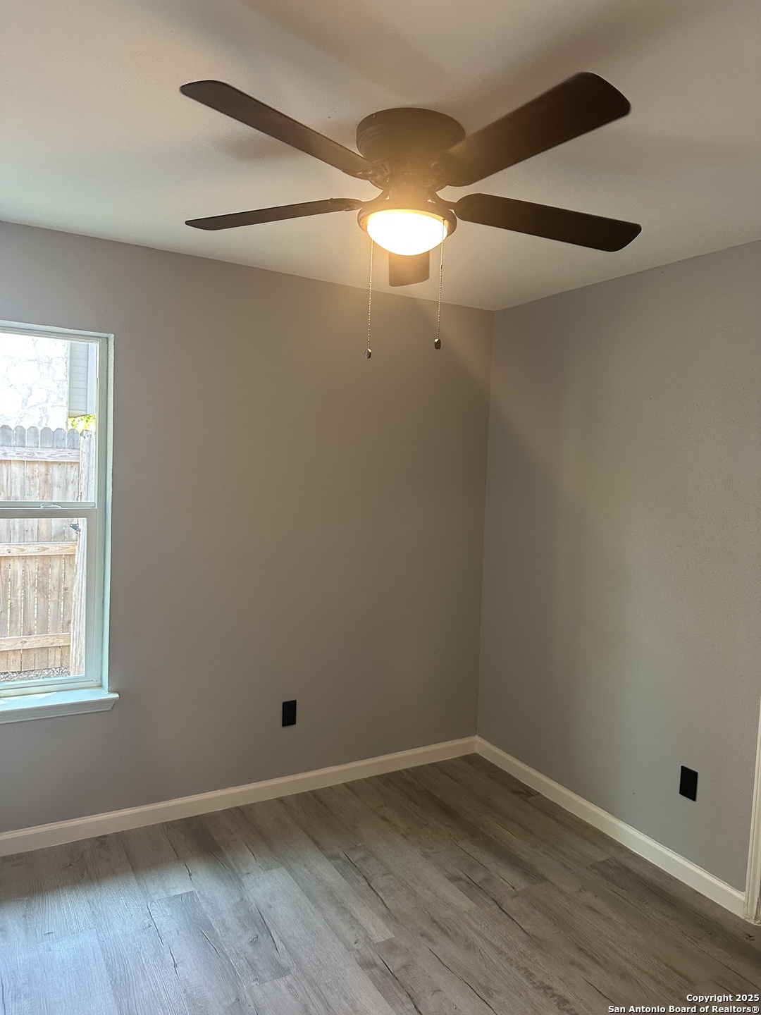 14627 Highland Ridge San Antonio, TX 78233 - Photo 14 of 25 an empty room with wooden floor and windows