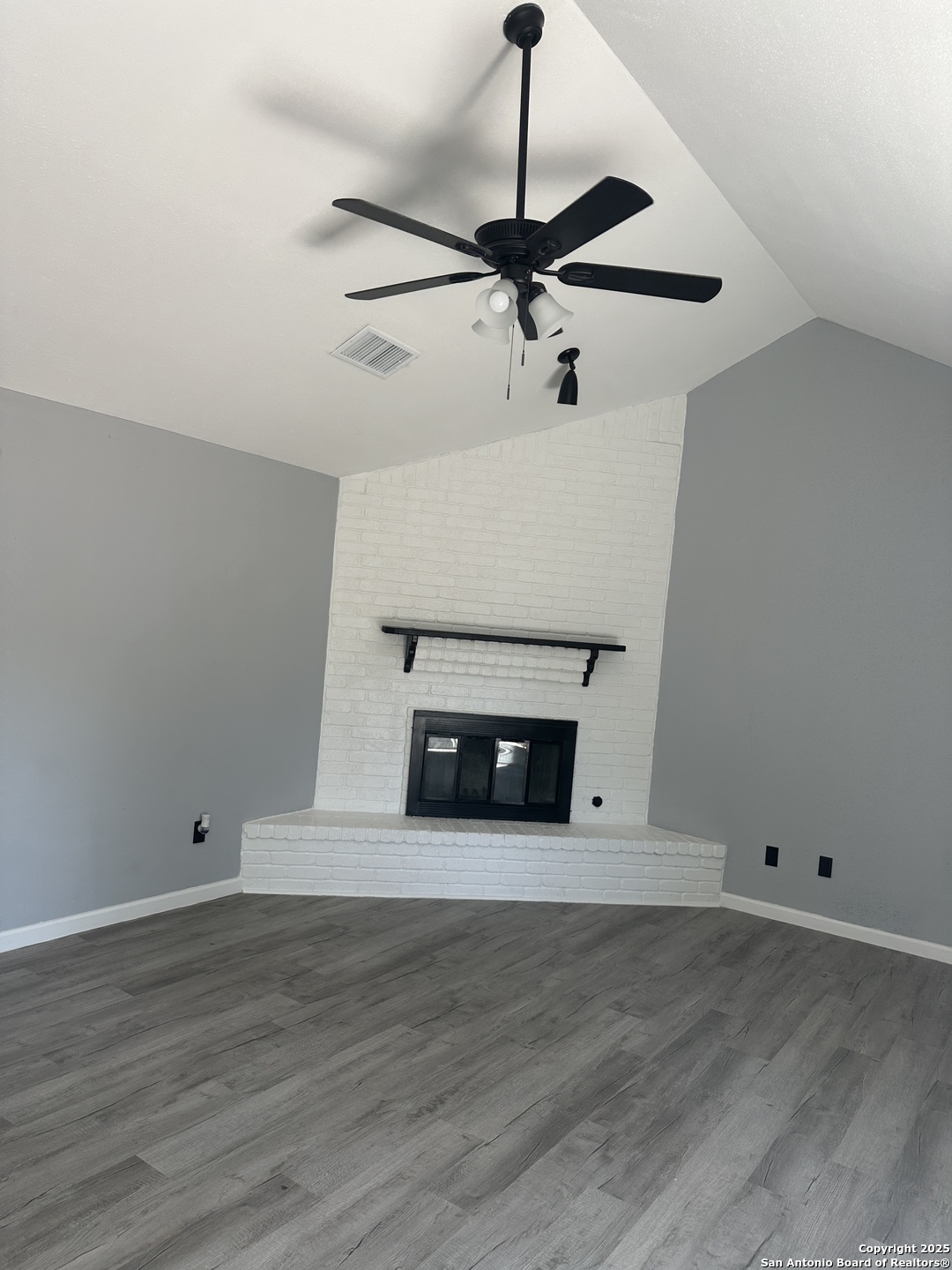 14627 Highland Ridge San Antonio, TX 78233 - Photo 25 of 25 a view of an empty room with a chandelier fan and wooden floor