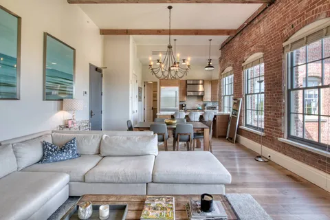 a living room with furniture chandelier and a large window
