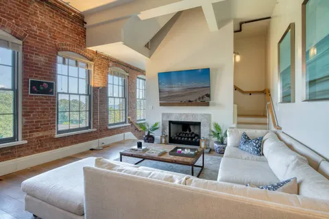 a living room with furniture a flat screen tv and a fireplace