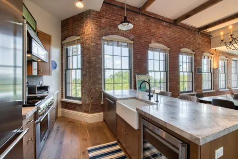 a kitchen with stainless steel appliances a sink a stove and wooden floor