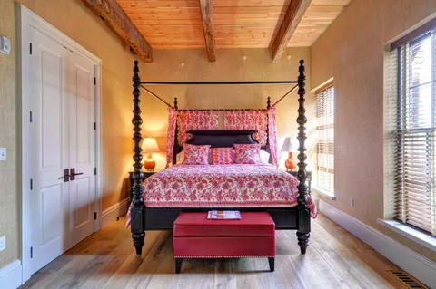 a bed sitting in a bedroom next to a window