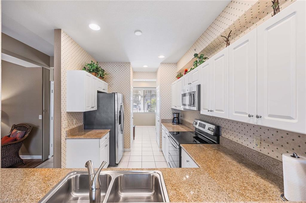 Undisclosed Address Naples, FL 34113 - Photo 6 of 38 a kitchen with stainless steel appliances granite countertop a sink refrigerator and cabinets