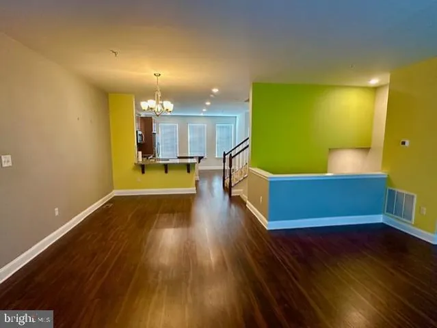 a view of a living room with kitchen and wooden floor