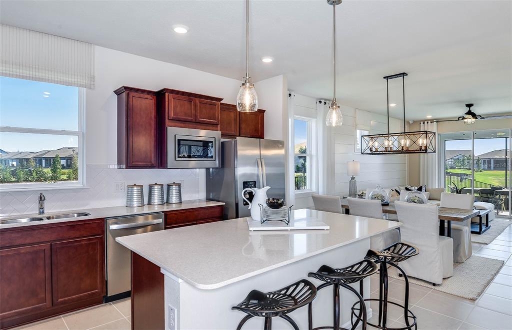 13693 Cyn Rdg Road Spring Hill, FL 34610 - Photo 2 of 29 a kitchen with stainless steel appliances kitchen island granite countertop a table chairs and a sink